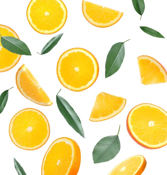 Літаючі соковиті апельсинові скибочки та цитрусове листя на білому тлі — стокове фото