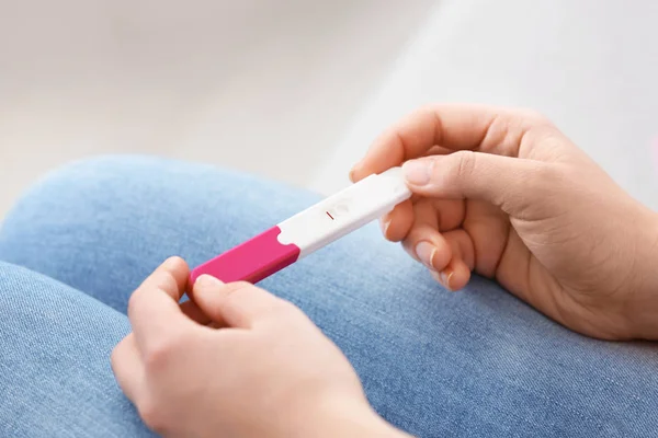 Mujer joven con prueba de embarazo en el interior, primer plano. Ginecología y parto — Foto de Stock