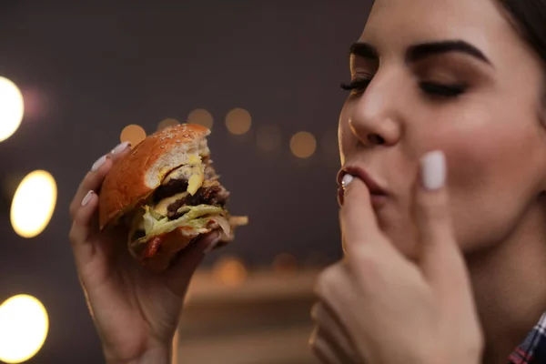 카페에서 맛 있는 햄버거를 먹고 젊은 여자 — 스톡 사진