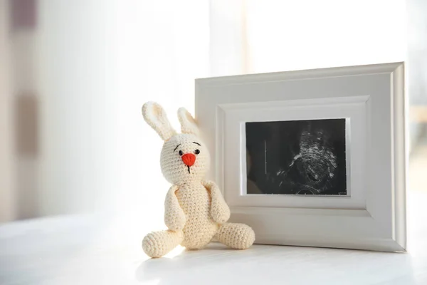 Imagem de ultra-som de bebê e brinquedo na mesa dentro de casa, espaço para texto — Fotografia de Stock