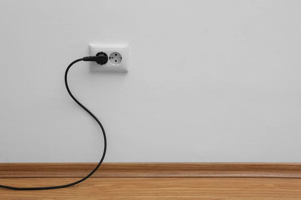 Power socket and plug on wall indoors, space for text. Electrician's equipment — Stock Photo, Image