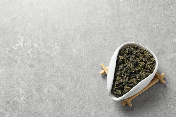 Chahe di cravatta Guan Yin oolong tè foglie su sfondo grigio, vista dall'alto con spazio per il testo — Foto Stock