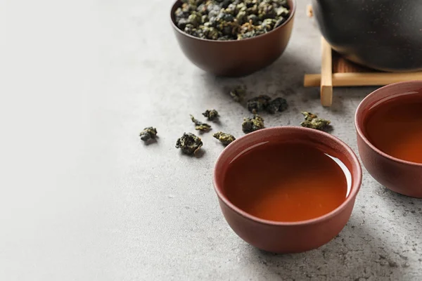 Poharak és Tie Guan Yin oolong tea levelek szürke tábla. Hely a szöveg — Stock Fotó