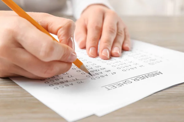 Studente che compila il foglio di risposta a tavola, primo piano — Foto Stock