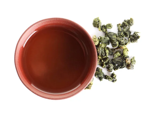 Taça de Tie Guan Yin oolong e folhas de chá no fundo branco, vista superior — Fotografia de Stock