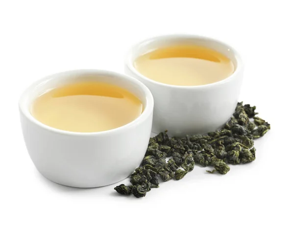 Copos de Tie Guan Yin oolong e folhas de chá no fundo branco — Fotografia de Stock