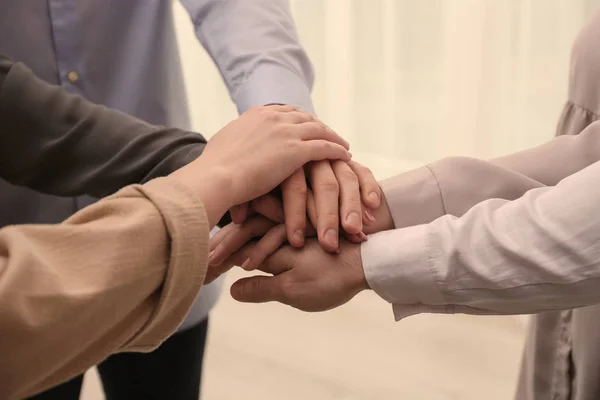 Group of people holding their hands together on blurred background, closeup — Stock Photo, Image