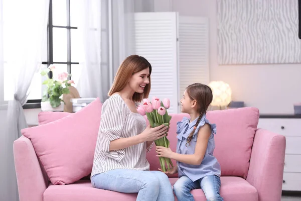 Feliz madre e hija con flores en casa. Día Internacional de la Mujer — Foto de Stock