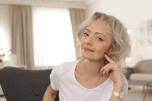 Portret van een volwassen vrouw in de woonkamer — Stockfoto