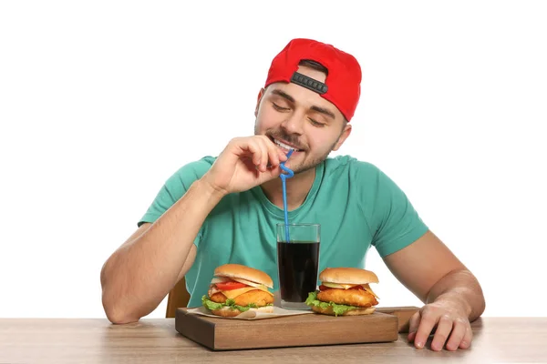 Stilig man ha lunch med hamburgare vid bord på vit bakgrund — Stockfoto