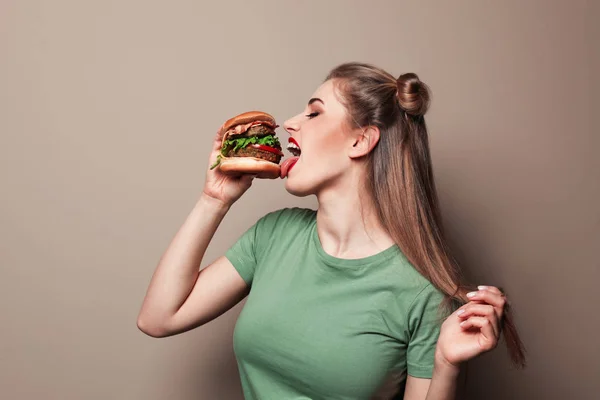 Güzel kadın lezzetli burger renkli arka plan üzerinde yemek. Metin için yer — Stok fotoğraf