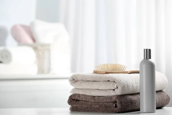 Handtücher mit Haarbürste und Shampoo auf dem Tisch. Raum für Text — Stockfoto