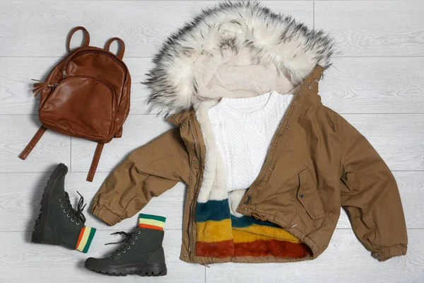 Conjunto de ropa de abrigo sobre fondo de madera, plano. Vacaciones de invierno —  Fotos de Stock