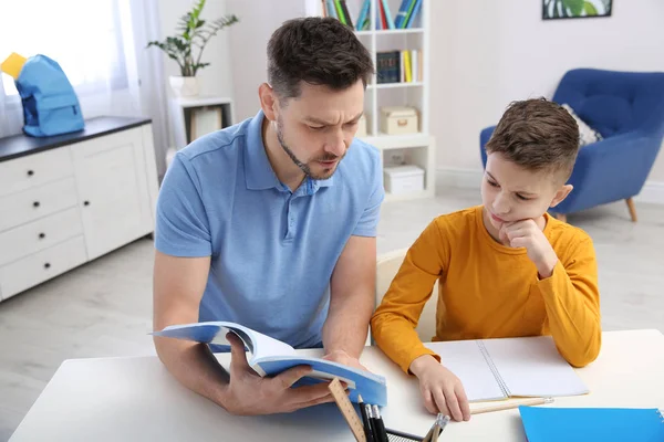 Papá ayudando a su hijo con la tarea en la habitación — Foto de Stock