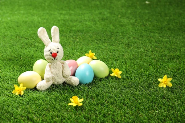 可爱的复活节兔子玩具和染色鸡蛋上的绿草, 文字空间 — 图库照片