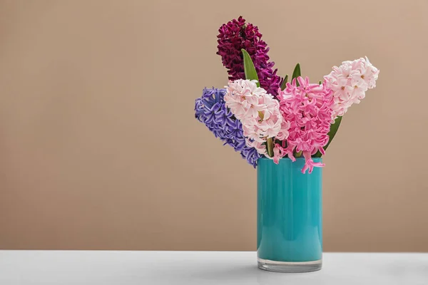 Hermosos jacintos en jarrón azul en la mesa contra el fondo de color, espacio para el texto. Flores de primavera — Foto de Stock