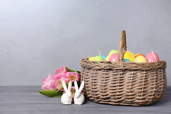 Kerámia nyuszik-húsvéti tojás és a fából készült asztal világos háttér, hely a szöveg tavaszi tulipán fonott kosár közelében — Stock Fotó