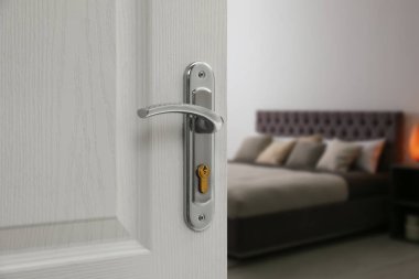 Yatak odasına önde gelen anahtar deliği açık ahşap kapı