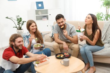 Oturma odasında birlikte yemeğe gençler. Food teslim