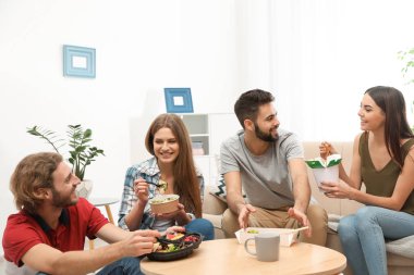 Oturma odasında birlikte yemeğe gençler. Food teslim