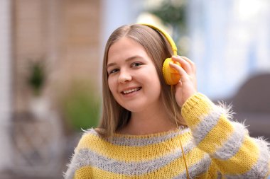 Mutlu genç kız evde kulaklık ile müzik dinlemek