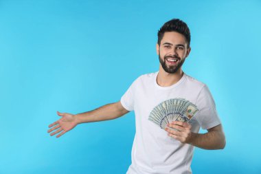 Renk arka plan üzerinde para ile mutlu genç adam portresi. Metin için yer