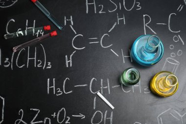 Laboratuar kapkacakları ile kimyasal formüller, düz yazı tahtası üzerinde yatıyordu