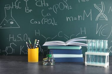 Blackboard kimyasal formüller ile karşı masada laboratuvar cam ve okul malzemeleri