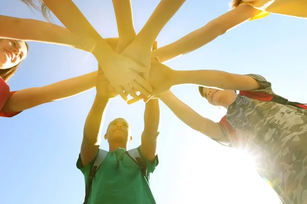 Grupp frivilliga sätta händerna ihop utomhus, underifrån — Stockfoto
