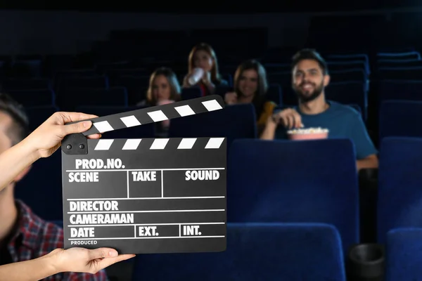 Frau mit Klappbrett und Menschen, die Filme im Kino schauen. Raum für Text — Stockfoto