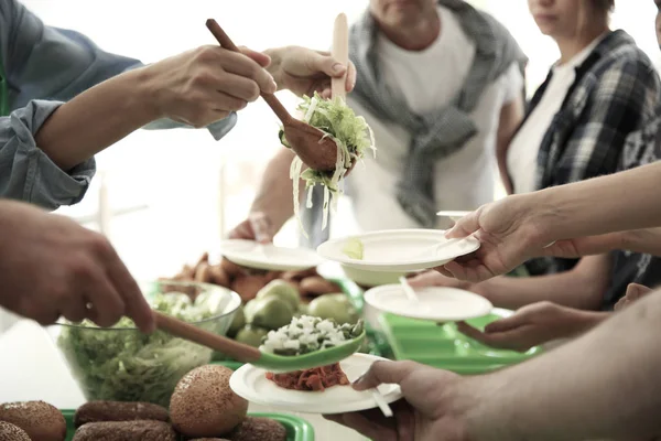 Voluntarios sirviendo comida para pobres en el interior — Foto de Stock