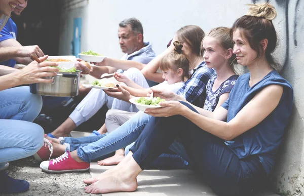Voluntarios sirviendo comida para pobres al aire libre — Foto de Stock