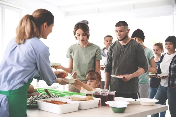 Voluntariado sirviendo comida para pobres en el interior — Foto de Stock