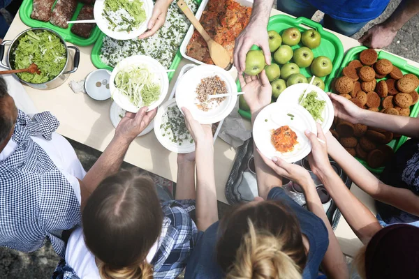 Voluntarios sirviendo comida para pobres al aire libre — Foto de Stock