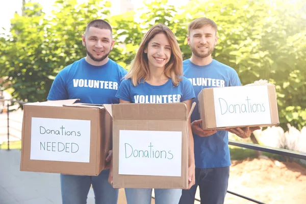 Equipo de voluntarios con cajas de donación al aire libre — Foto de Stock