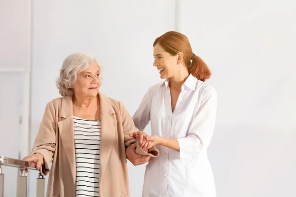 Volunteer helping senior woman indoors. Space for text — Stock Photo, Image