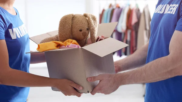 Des bénévoles tiennent une boîte avec des dons à l'intérieur, en gros plan — Photo