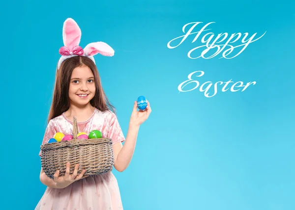 Niña en orejas de conejo diadema celebración cesta con huevos en el fondo de color. Feliz Pascua — Foto de Stock