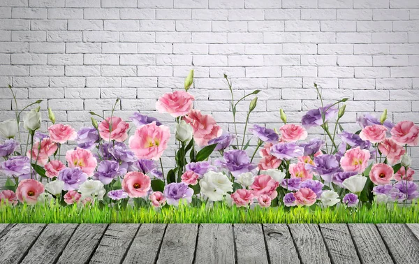 Terraço de madeira perto de flores florescentes e cerca de tijolo ao ar livre, espaço para texto. Jardinagem de paisagem — Fotografia de Stock