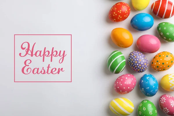 Composición plana de huevos pintados y texto Feliz Pascua sobre fondo claro — Foto de Stock