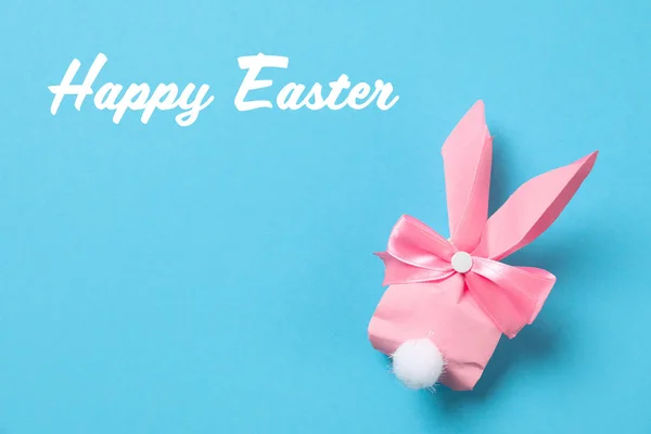 Bolsa de regalo de conejito creativo y texto Feliz Pascua sobre fondo de color, vista superior — Foto de Stock