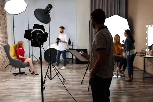 Estúdio fotográfico com equipamentos profissionais e equipe de trabalhadores — Fotografia de Stock