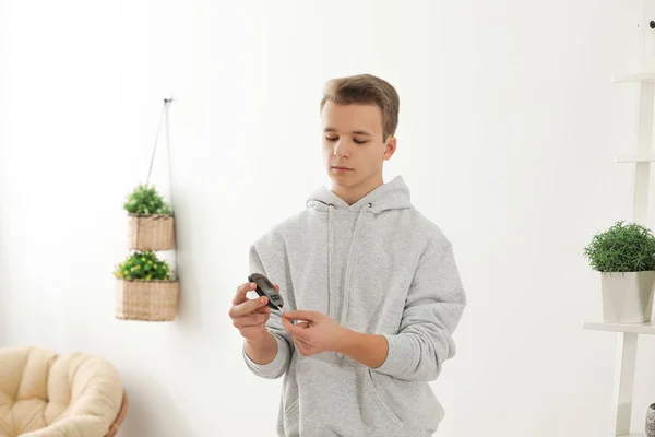 Adolescente segurando glicosímetro digital em casa. Controlo da diabetes — Fotografia de Stock