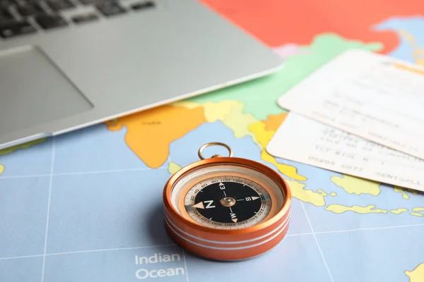 Compass, tickets and laptop on world map. Travel agency — Stock Photo, Image