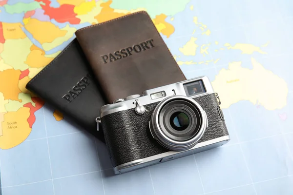 Passaporti e macchina fotografica sulla mappa del mondo. Agenzia di viaggi — Foto Stock