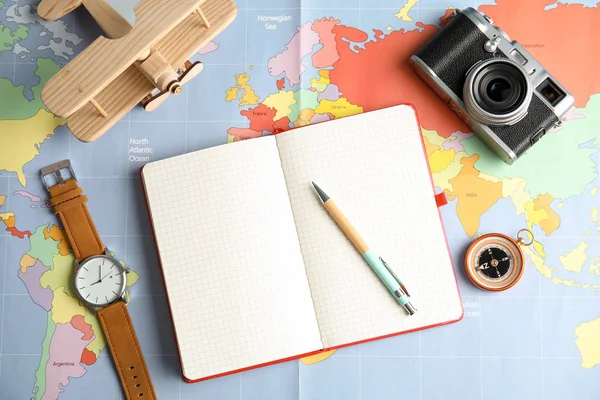 Επίπεδη lay σύνθεση με σημειωματάριο και φωτογραφική μηχανή στο χάρτη του κόσμου, χώρο για το κείμενο. Ταξιδιωτικό πρακτορείο — Φωτογραφία Αρχείου