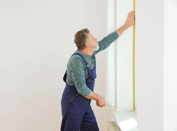 Сервисмен подбирает окно для установки внутри помещения. Пространство для текста — стоковое фото