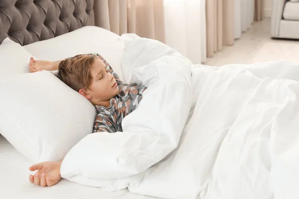 Lindo chico cansado durmiendo en una cama cómoda —  Fotos de Stock