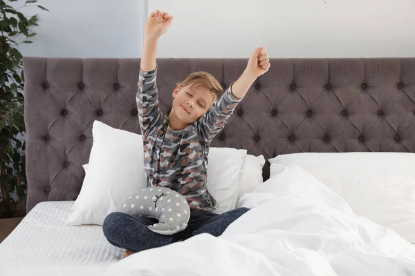 Garçon mignon avec jouet étirant après le sommeil sur le lit. Espace pour le texte — Photo