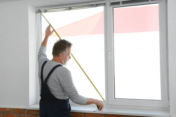 Servicekraft misst Fenster für den Einbau in Innenräume — Stockfoto